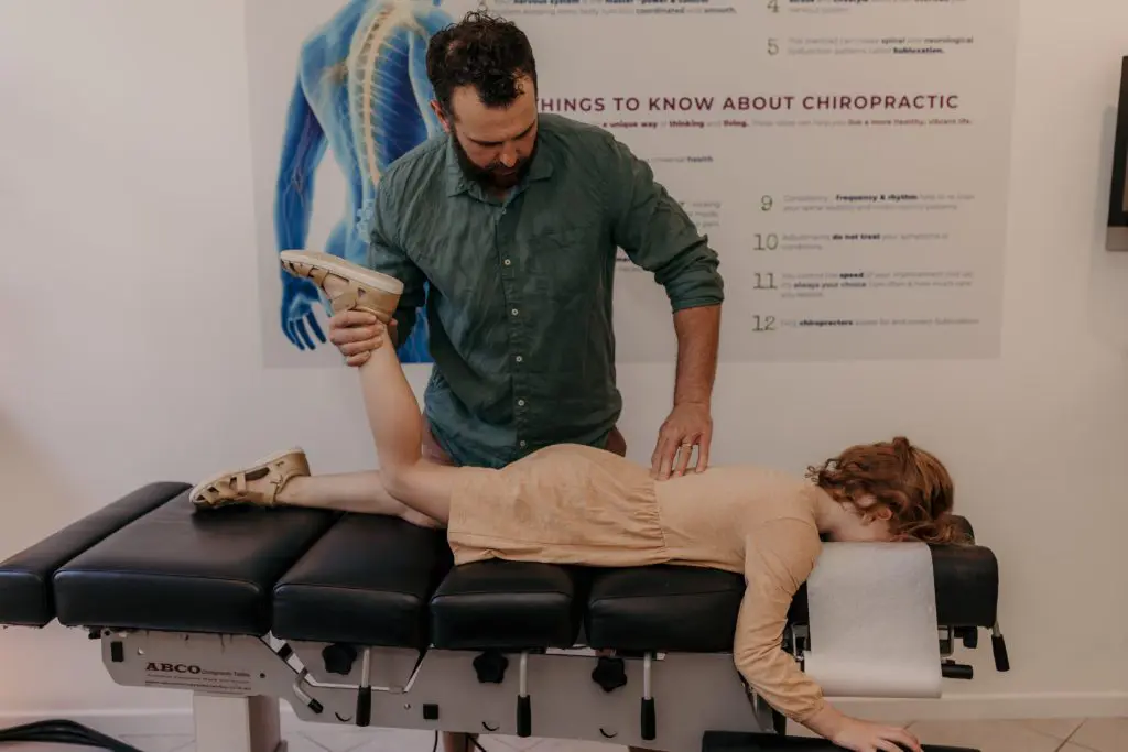 Adam adjusting a client - Benefits of Chiropractic Care