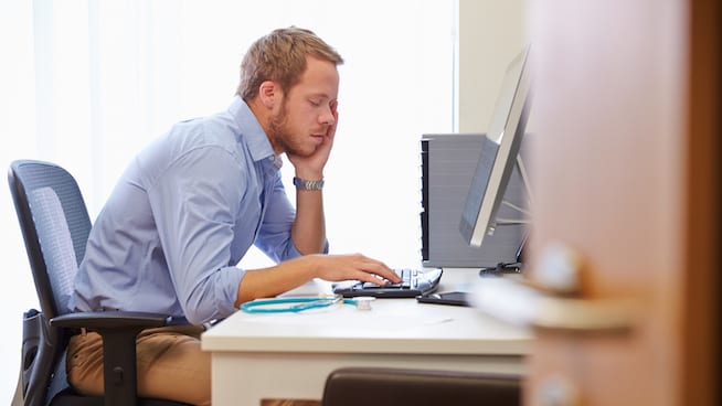 Overworked Man Sitting at Computer